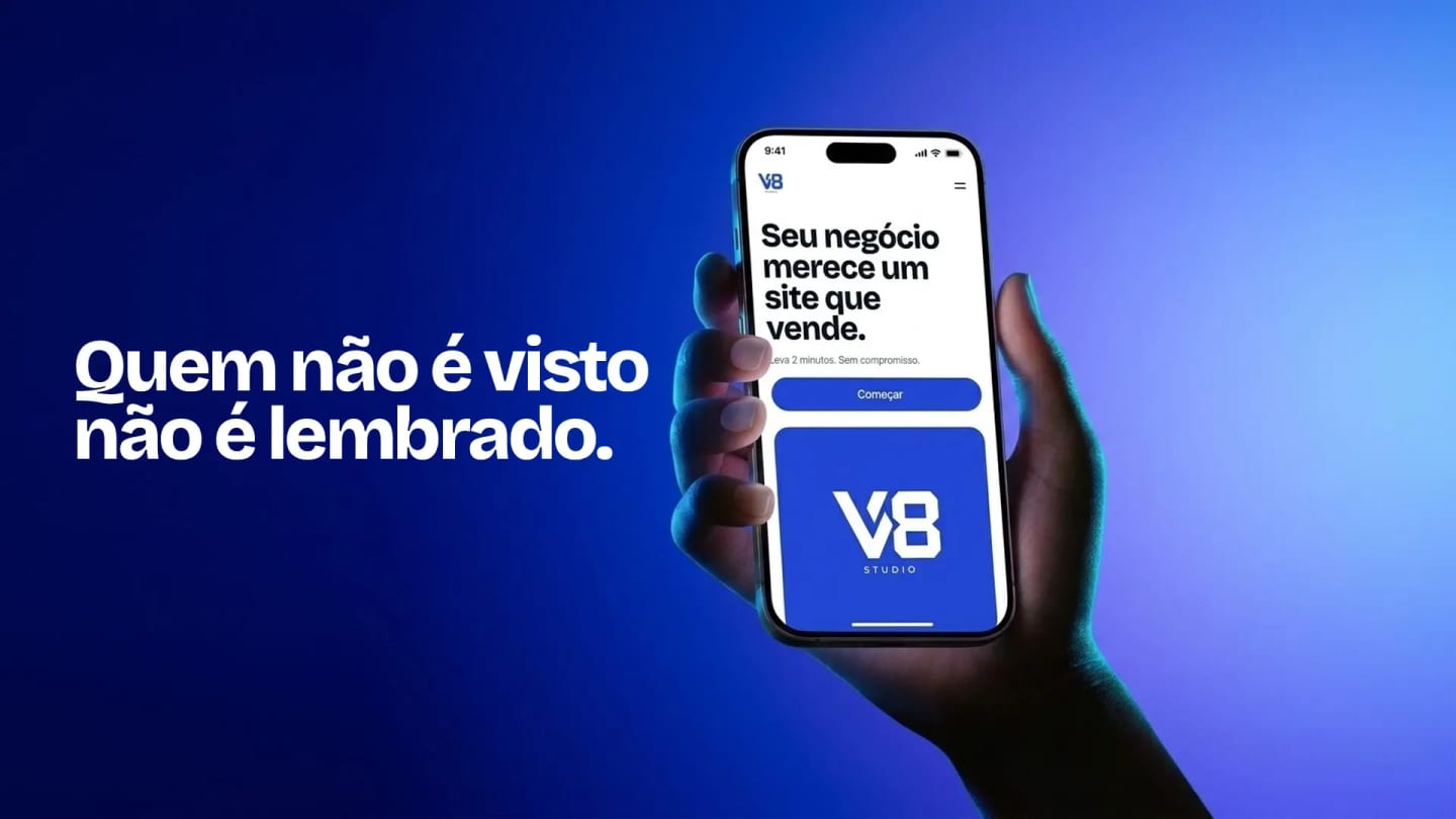 Mão segurando um celular com o site da V8 Studio aberto: Seu negócio merece um site que vende, o botão Começar e o logo V8 Studio.